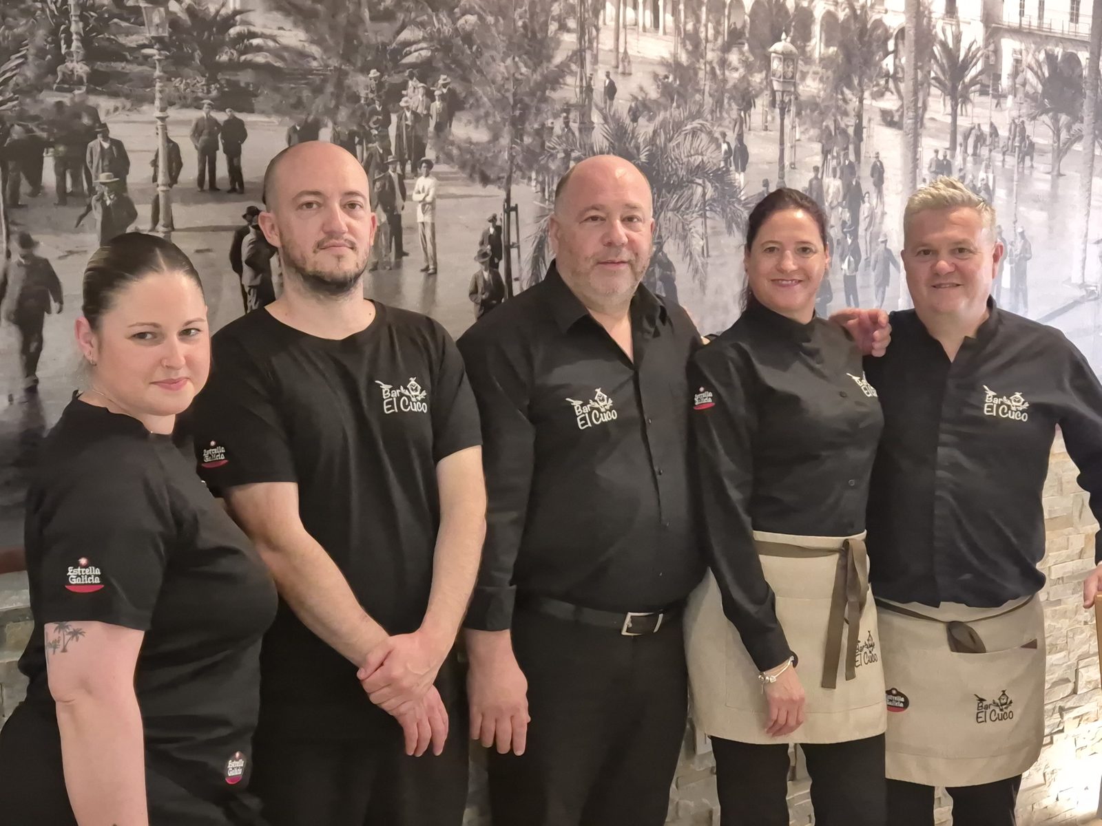 El equipo de Bar El Cuco en el comedor, delante del mural de Jerez